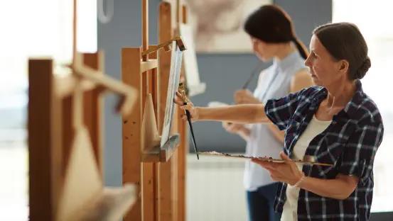 two women painting on canvas